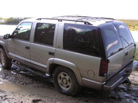 2000 Chevrolet Tahoe - This SUV appears to be stuck in a muddy area, possibly off-roading or after heavy rain.