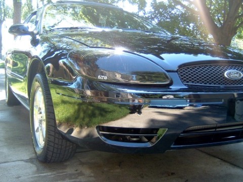 2004 Ford Taurus - Front view of a black 2004 Ford Taurus, showing the grille and headlights.