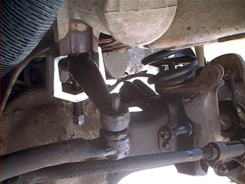 1995 Ford Bronco - Underbody view of a Ford Bronco's front suspension and steering components, showing the differential housing, coil spring, radius arm, and…