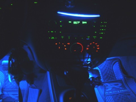 2004 Ford Taurus - The interior of a car is illuminated with blue ambient lighting, highlighting the dashboard and floor mats.