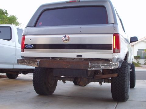 1993 Ford Bronco - Rear view of a lifted 1993 Ford Bronco a custom bumper and an American flag emblem on the tailgate.