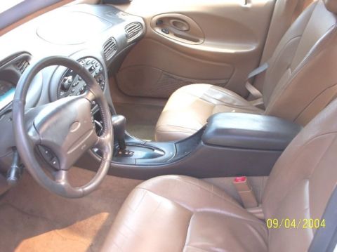 1997 Ford Taurus - The interior of a 1997 Ford Taurus is captured, highlighting the dashboard and seating area around the gear shifter.