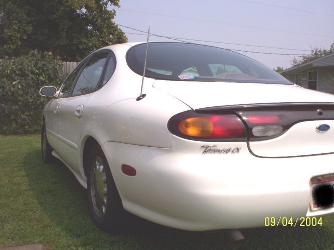 1997 Ford Taurus sedan, rear quarter view, parked on grass with trees and a house in the background. Watermark shows 09/04/2004