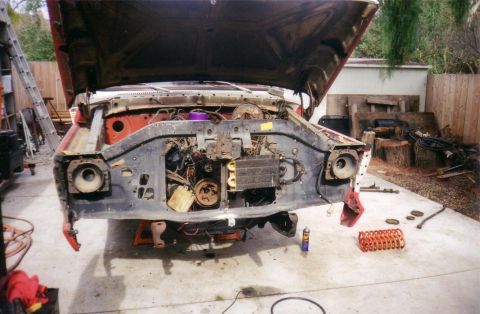 1978 Ford Bronco - The front of a 1978 Ford Bronco is shown with its hood open and the engine bay disassembled.
