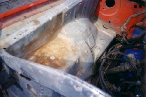 1978 Ford Bronco - The engine bay of a vehicle shows signs of rust and exposed wiring, indicating it may be undergoing restoration or repair.