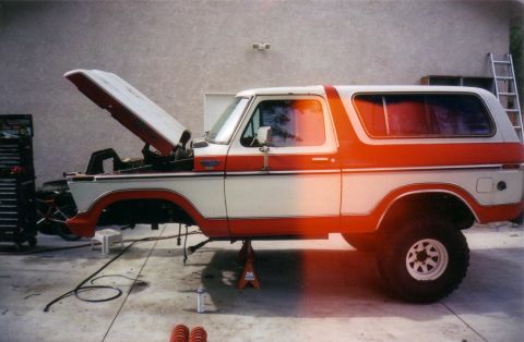 1978 Ford Bronco - This 1978 Ford Bronco is shown in a side profile, undergoing maintenance with its hood open and resting on jack stands.