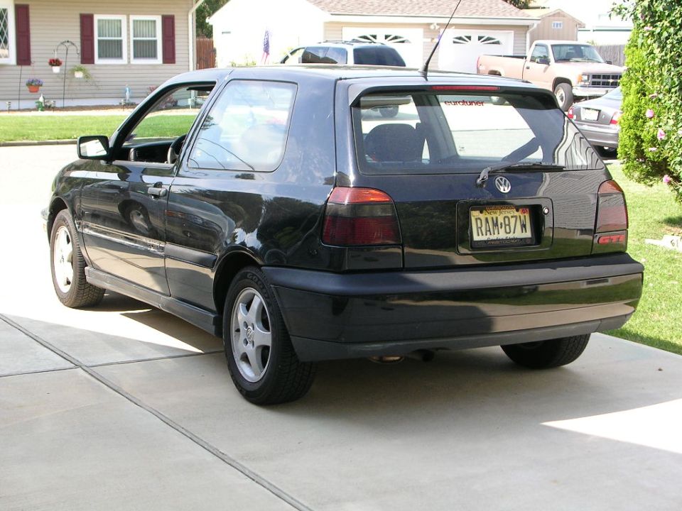 Black Volkswagen Golf GTI parked in driveway, rear view. License plate RAM-87W