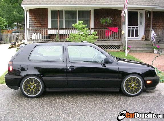 black Volkswagen Golf GTI parked in front of a house