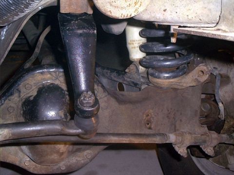 1995 Ford Bronco - A close-up underbody view of a Ford solid-axle front suspension, showing the coil spring, radius arm, ball joint, tie-rod end and steering…