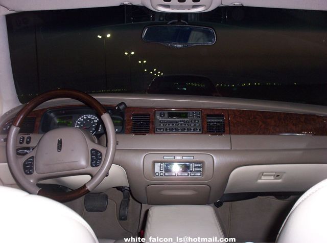Interior view of a 1999 Lincoln Town Car with wood trim and beige interior
