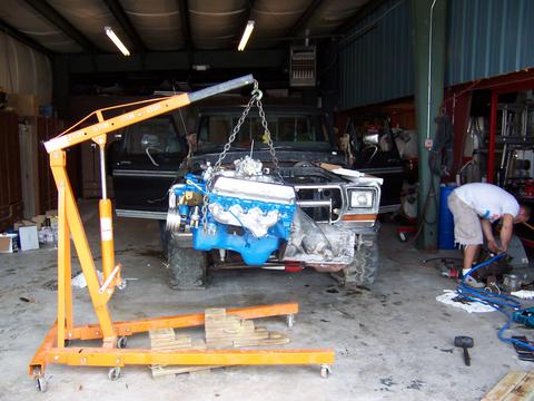 1979 Ford F-150 - A 1979 Ford F-150 is in a garage with its engine being installed using an engine hoist.