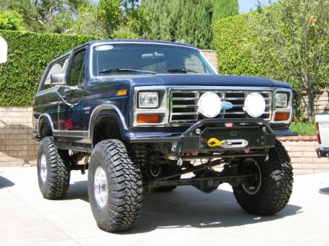 1985 Ford Bronco - This lifted Ford Bronco features a custom front bumper with a winch and auxiliary lights, giving it an aggressive off-road stance.