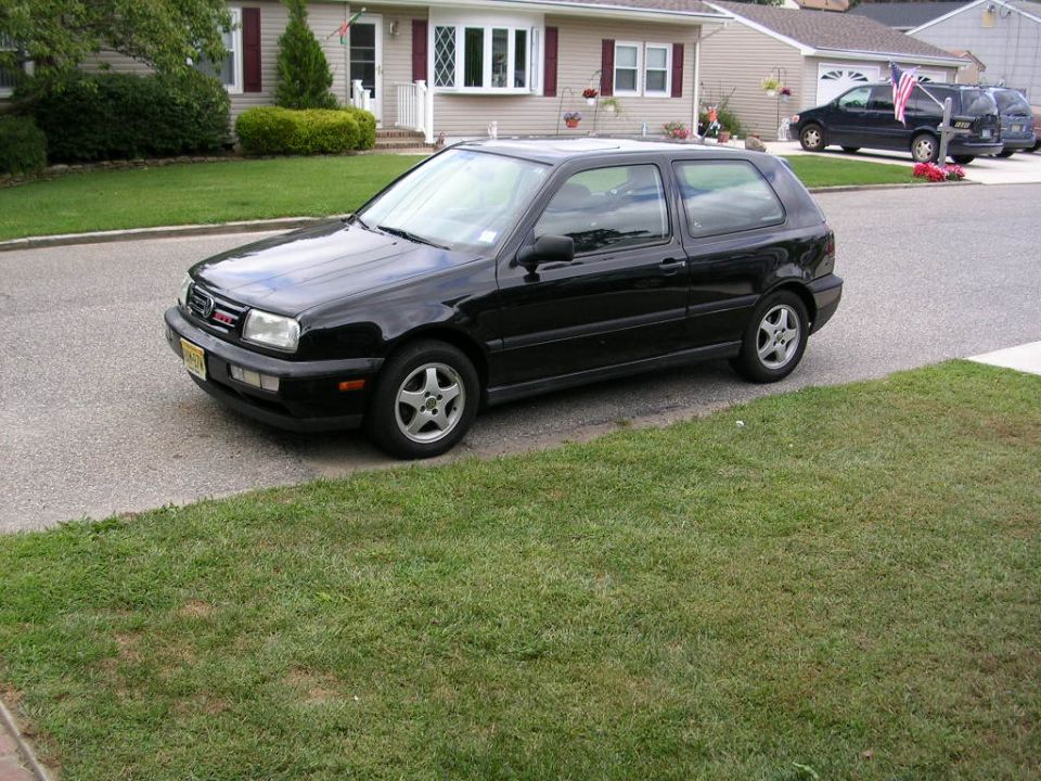 Black Volkswagen Golf GTI parked on a residential street, front three-quarter view