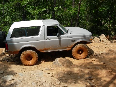 1995 Ford Bronco - This 1995 Ford Bronco navigates a rocky, off-road trail with mud splattered on its lower body.