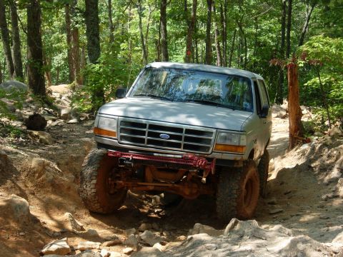 1995 Ford Bronco - This 1995 Ford Bronco tackles a challenging, wooded off-road course with large tires and lifted suspension.
