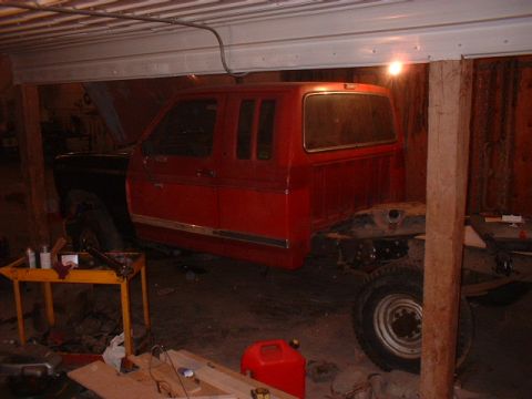 1986 Ford F-250 - The chassis of a red 1986 Ford F-250 pickup truck is visible, undergoing some form of work.
