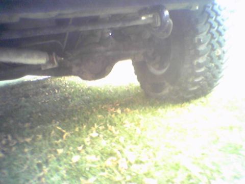 1993 Ford Bronco - The underside of a vehicle, showing the rear axle and a large off-road tire.