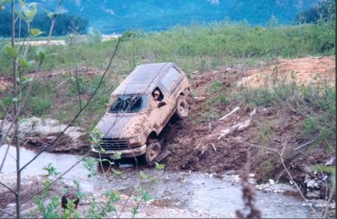1993 Ford Bronco - This SUV is navigating a muddy creek bed on an off-road trail.