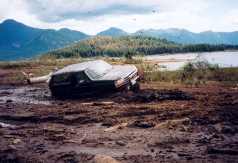 1993 Ford Bronco - This 1993 Ford Bronco is stuck deep in the mud near a lake and mountains.