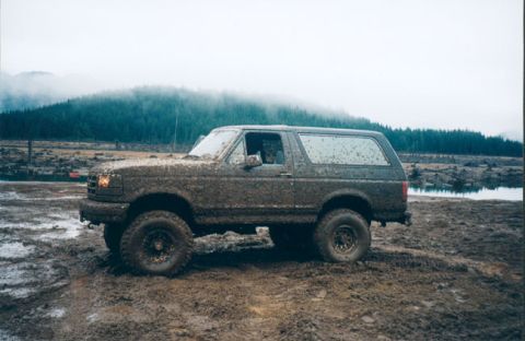 1993 Ford Bronco - This SUV is covered in mud after driving through a wet, off-road area.