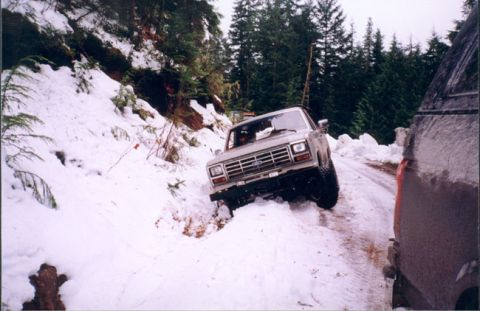 1993 Ford Bronco - Ford Bronco navigating a snow-covered road in a wooded area.
