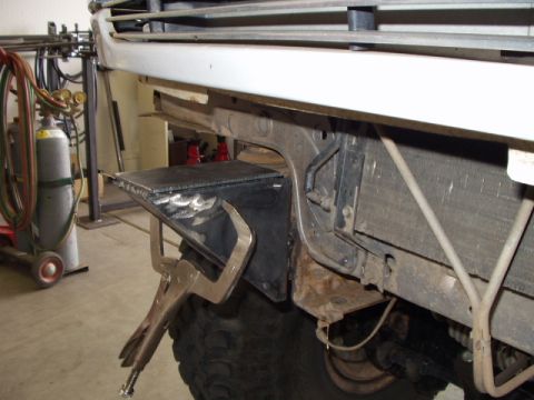 1993 Ford Bronco - Close-up of the front frame of a 1993 Ford Bronco, showing a metal plate being clamped near the radiator.