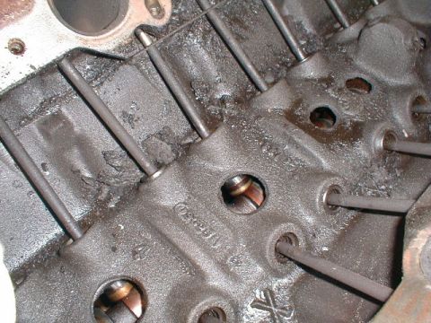 1990 Ford Bronco - Close-up view of an engine block showing pushrods and signs of carbon buildup.