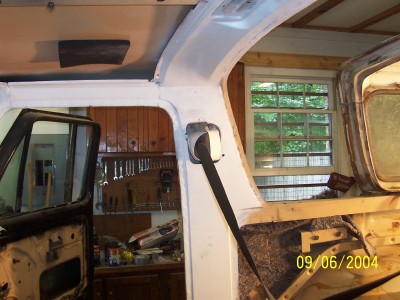 1979 Ford Bronco - The interior of a vehicle is shown with the door open, revealing a workbench and tools on the wall.