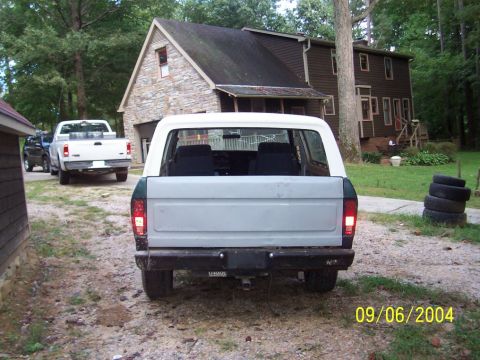 1979 Ford Bronco - A white and green SUV is parked in a driveway with a white pickup truck behind it. The photo was taken on September 6, 2004.