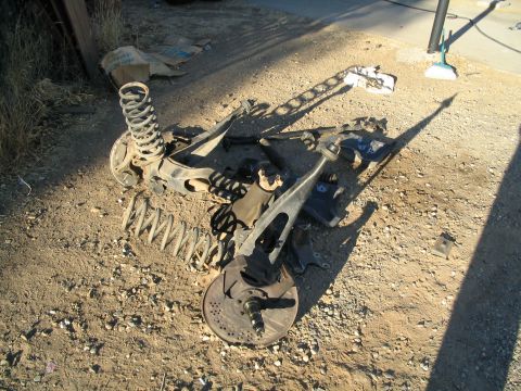 1989 Ford Bronco - Disassembled vehicle suspension components lie on the ground, with a SuperMotors.net watermark visible.