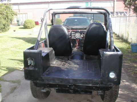 1979 Ford Bronco II - Rear view of a black Jeep CJ showing its interior, roll cage, and open bed.