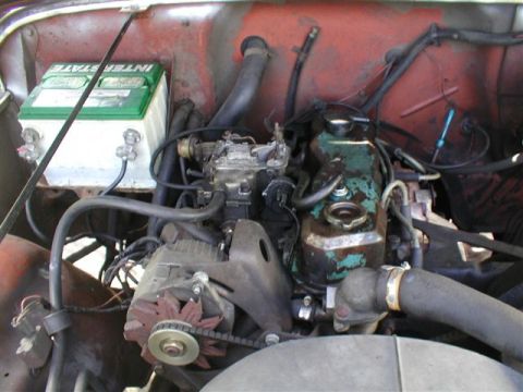 1979 Ford Bronco II - Engine bay details including battery, carburetor, and alternator. The firewall is painted red.
