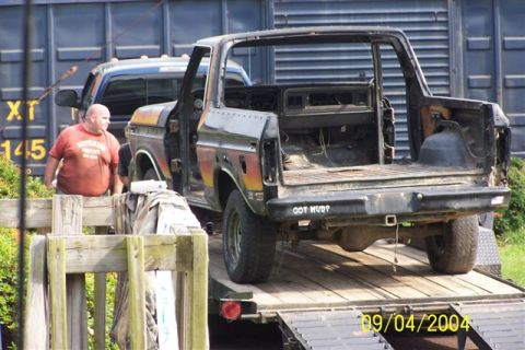 1979 Ford Bronco II - This old Ford Bronco is being transported on a trailer, with a man and another truck visible in the background.