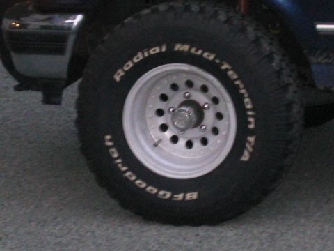 1994 Ford Bronco - A close-up shot focuses on the tire and wheel of a vehicle, with some of the body visible.