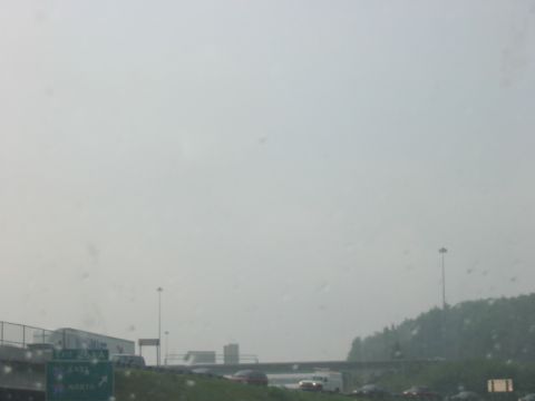1988 Ford Bronco - A hazy day on the highway shows multiple vehicles and road signs, with a truck visible on the left.