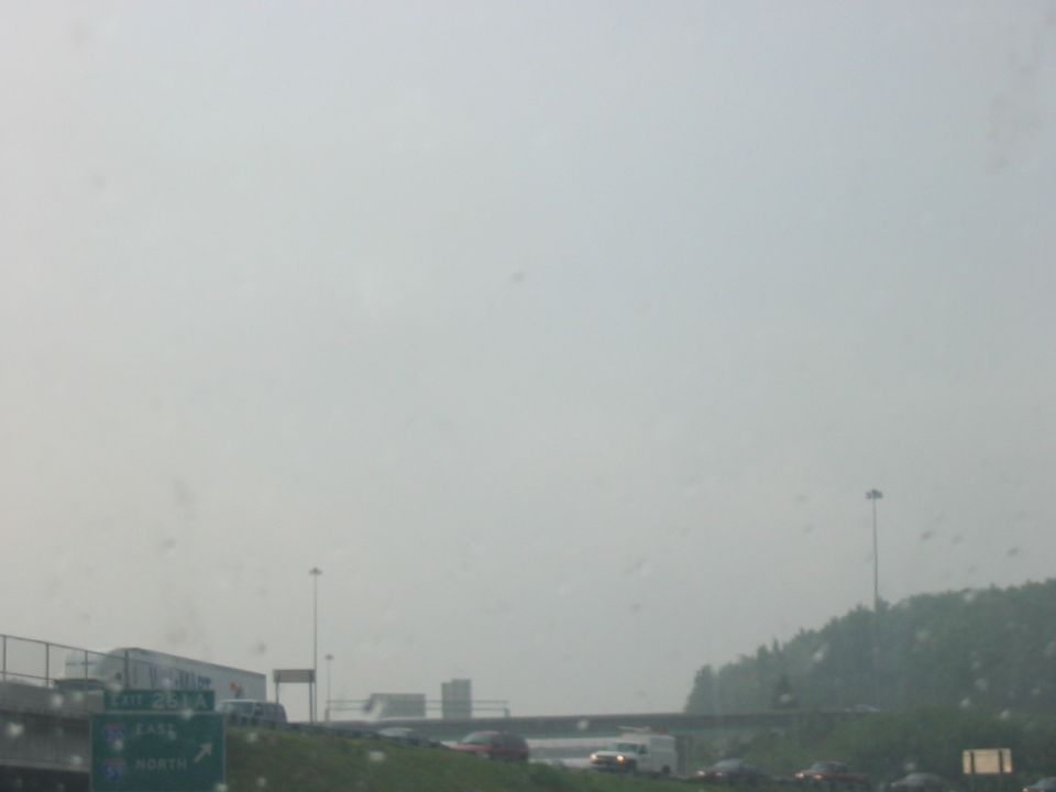 Highway scene with traffic and signs under a hazy sky