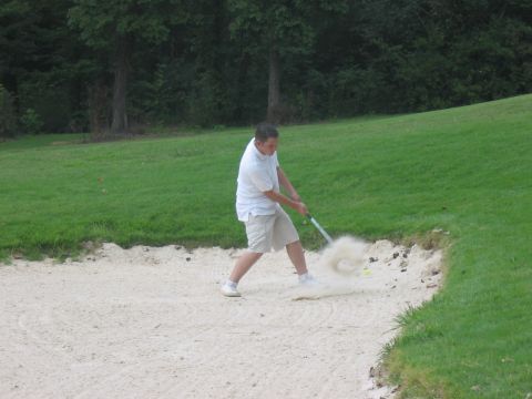 1988 Ford Bronco - A golfer attempts a shot from a sand trap on a golf course.