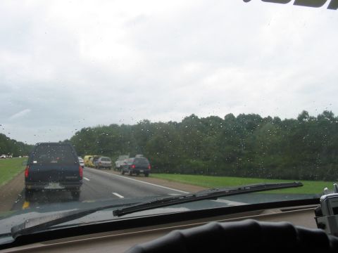 1988 Ford Bronco - View from inside a vehicle driving on a highway with multiple vehicles ahead on a cloudy day.