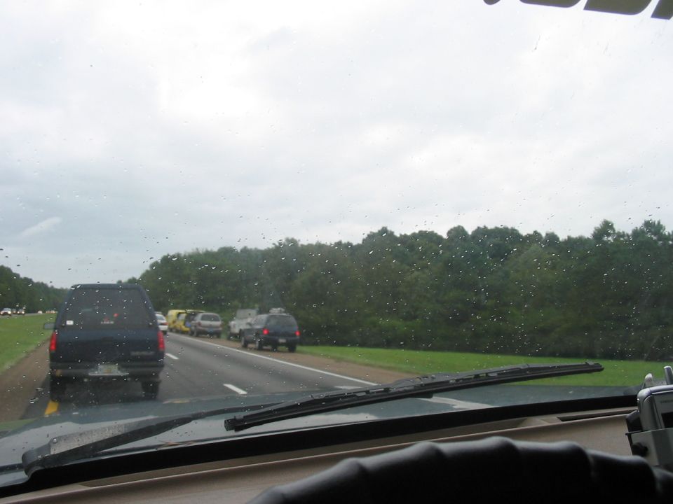 Driving on highway with several cars and vans ahead in traffic, cloudy day