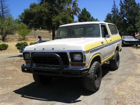 1978 Ford Bronco - 1978 Ford Bronco parked outdoors on a dirt road with trees and a person in the background.