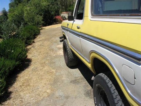 1978 Ford Bronco - Side view of a 1978 Ford Bronco with yellow and white paint, parked outdoors.