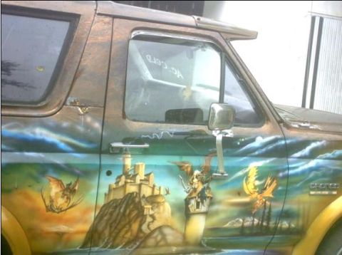 1992 Ford Bronco - This 1992 Ford Bronco features a detailed airbrushed mural of a fantasy landscape with dragons and a castle.