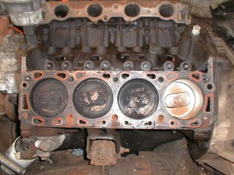 1990 Ford Bronco - Engine block with pistons visible, showing wear and oil residue.