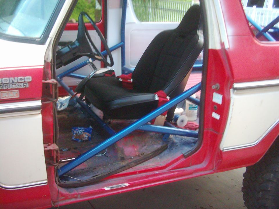 Red Bronco Ranger XLT doorway with blue roll cage and black bucket seat
