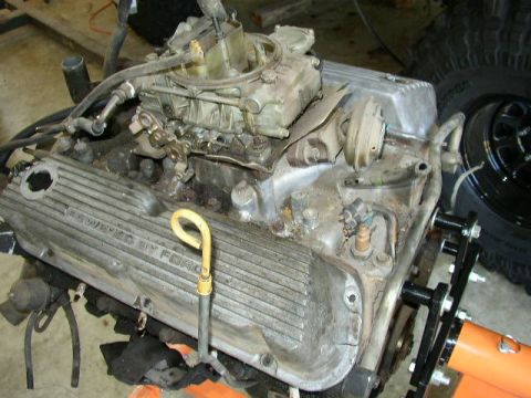 1995 Ford Bronco - A Ford engine is shown on an engine stand, with a carburetor and dipstick clearly visible.