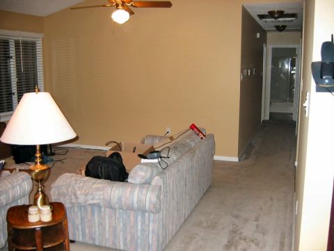 1985 Ford LTD Crown Victoria - A view of a living room and hallway, showing furniture and boxes, with a ceiling fan overhead.