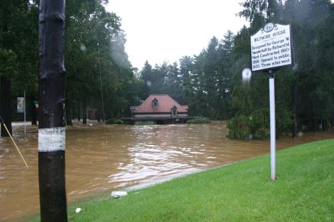 1985 Ford LTD Crown Victoria - The Biltmore House is submerged in floodwaters, with a historical marker visible in the foreground.