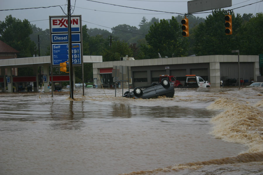 Overturned gray car in floodwaters near Exxon station