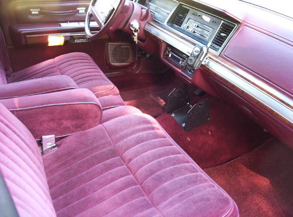 Maroon velour interior of a 1991 Ford Crown Victoria LTD, showing front seats, dashboard, and steering wheel