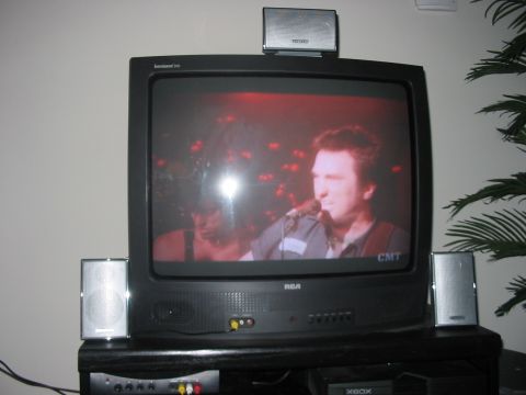1988 Ford Bronco - Television setup with speakers and a media player, showing a music performance on screen.